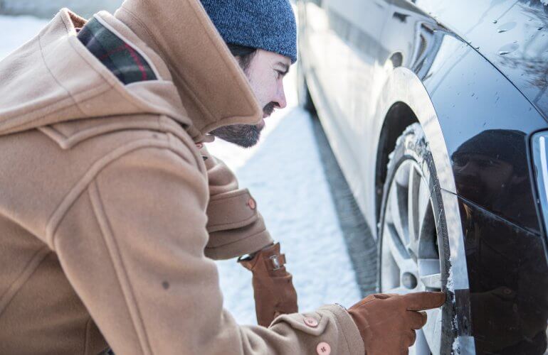 Man checkt winterbanden buiten