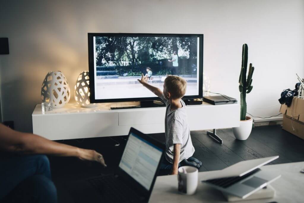 Jongetje raakt televisie aan die in de living staat