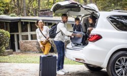 Gezin gaat met de auto op reis en laadt hun koffers in de auto in.